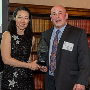 Woman handing trophy to man