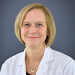 Melissa Davidson smiling in a white coat with a silver necklace on