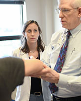 Dr Dale Stafford and medical student anna quinlan examine patient for use in deans newsletter