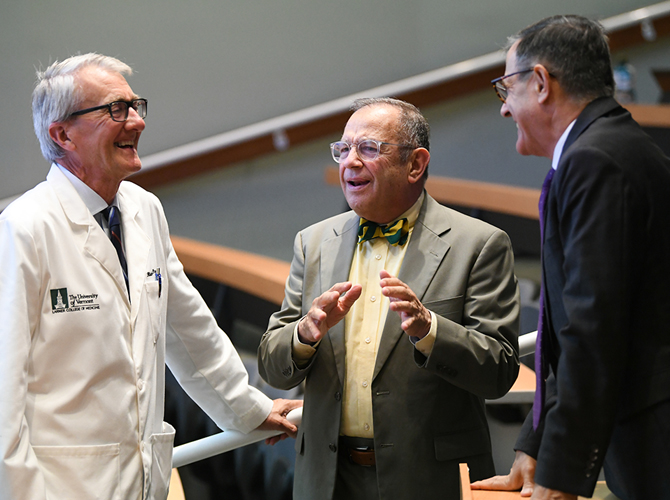 photo of three men gathering at lecture