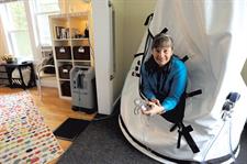 Woman looking out from hyperbaric chamber in pleasant office surroundings