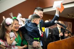 Photo of family at podium, with student holding opened match letter