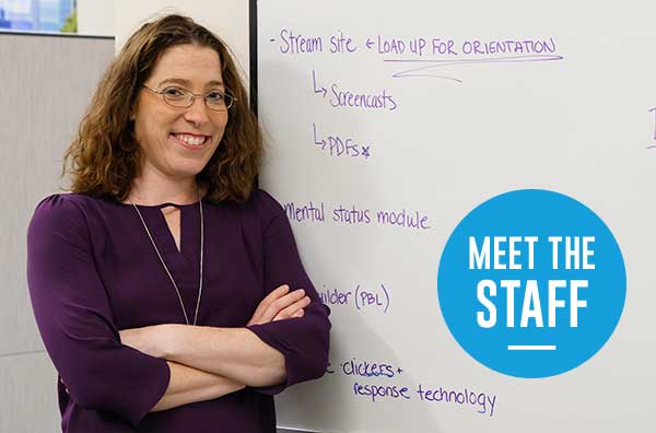 Laurie Gellis posing in front of a dry erase board