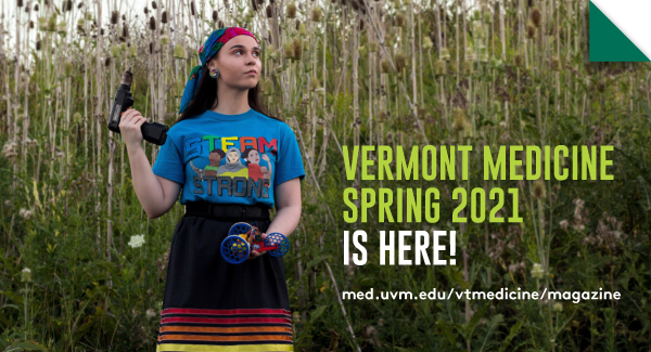 Newsletter 3 Ms. Boyer poses in a field wearing a “STEAM STRONG” logo t-shirt and holding a screwdriver in one hand and a robotic model in the other.