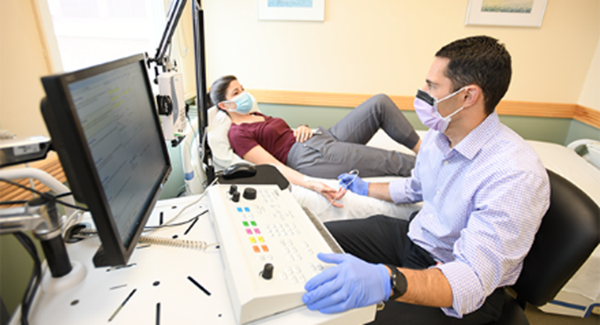 Dr. Kolb (at right) with a patient in an exam room.