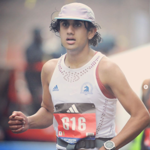 Person in a sun hat running in the 2023 Boston Marathon