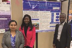 Trishnee with grad students Trishnee with grad students Victoria Idehai and Pindar Mbaya standing in front of a poster at a conference